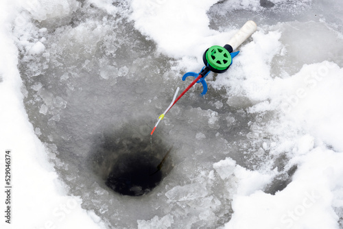 ice fishing. winter fishing. The fishing rod lies in the snow