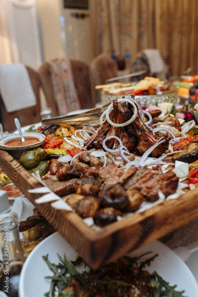 grilled meat set on a wooden board on the table