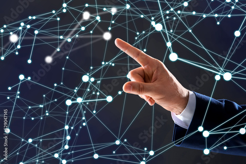 Man using virtual screen with connection lines presenting innovation network linkage on dark background