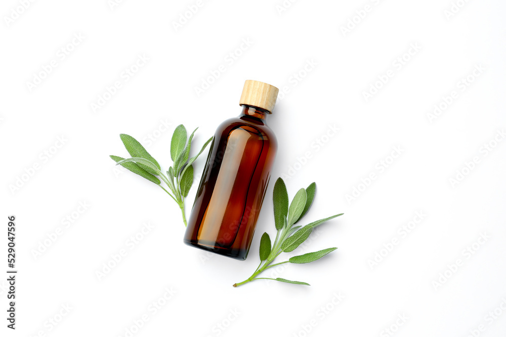 Bottles of essential sage oil and twigs on white background, top view Bottles of essential sage oil and twigs on white background, top view