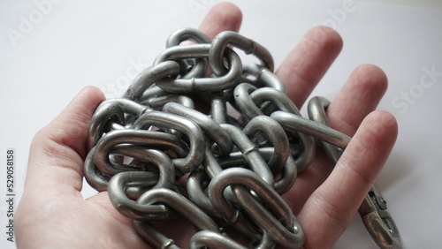 Rolled up metal chain in hand