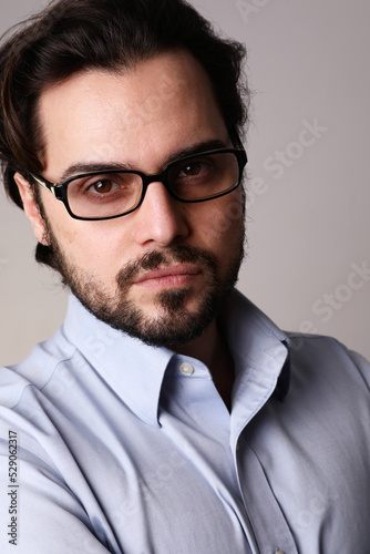 Close-up of business man standing in corporate portrait isolated on white wall.