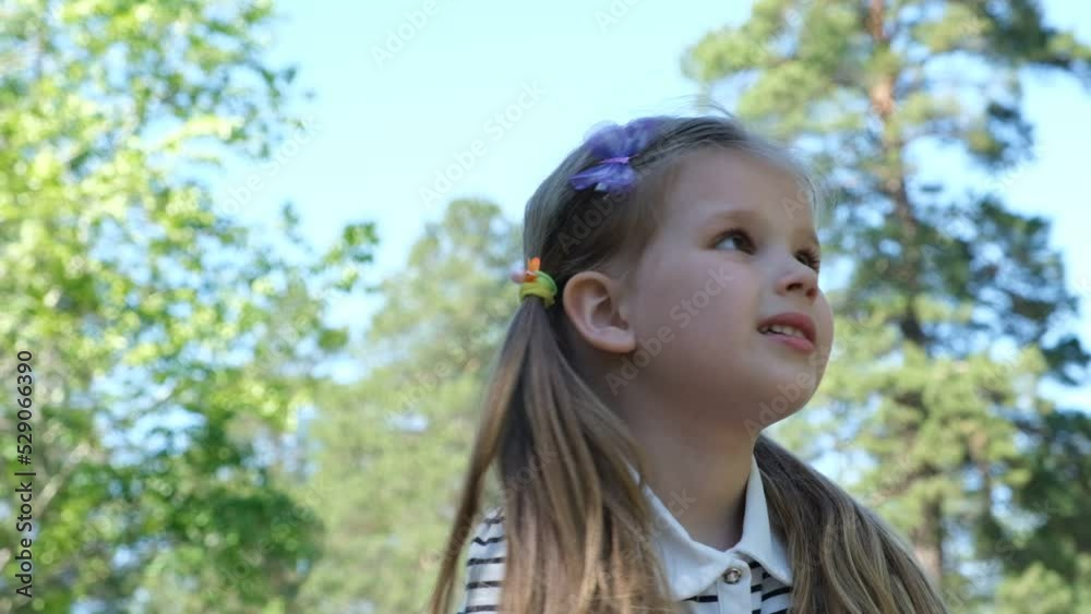 Toddler girl with emotions watching for insects or birds in the forest or garden Toddler girl with emotions watching for insects or birds in the forest or garden