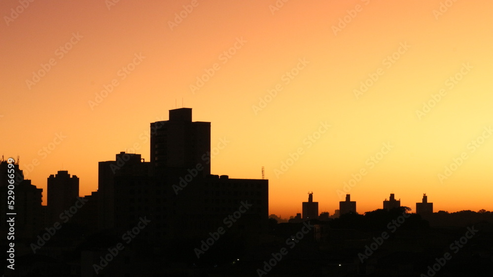 SAO PAULO, SAO PAULO, BRAZIL - JULY 05 2022: Building silhoutte at the sunrise. Four little building at the background