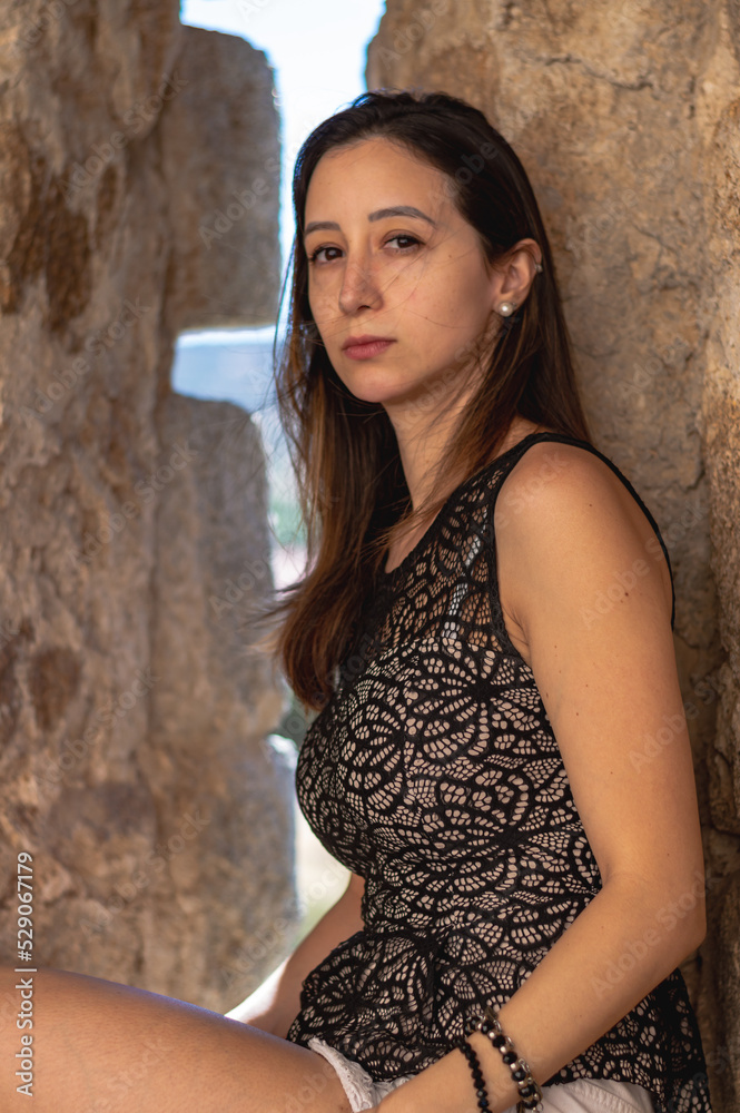 Fototapeta premium Portrait young attractive woman look at camera serious standing over isolated stone wall background