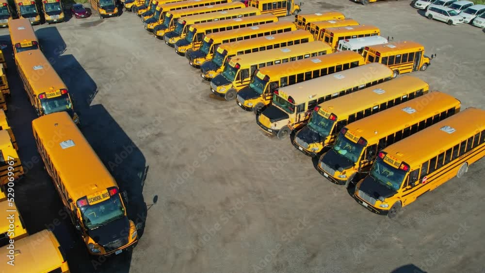 The parking full of school buses waiting for educational season. Row filled with many school bus ready to pick up students to school. Aerial view. The parking full of school buses waiting for educational season. Row filled with many school bus ready to pick up students to school. Aerial view.