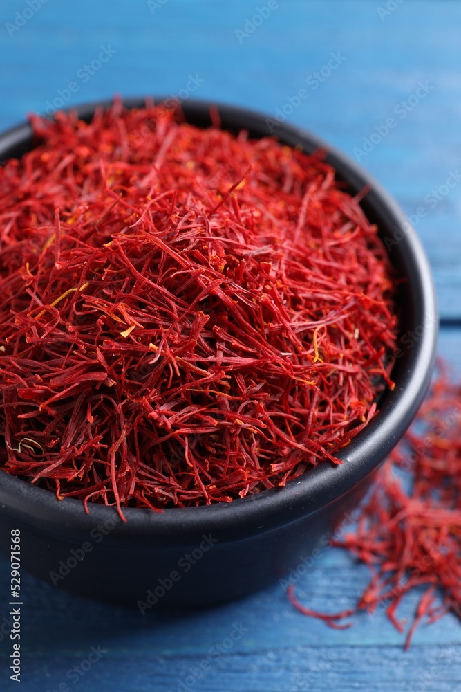 Fototapeta premium Dried saffron on blue wooden table, closeup