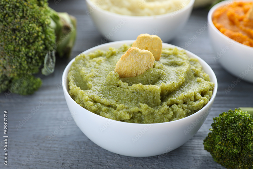 Bowl with tasty green puree and ingredients on light blue wooden table, closeup Bowl with tasty green puree and ingredients on light blue wooden table, closeup