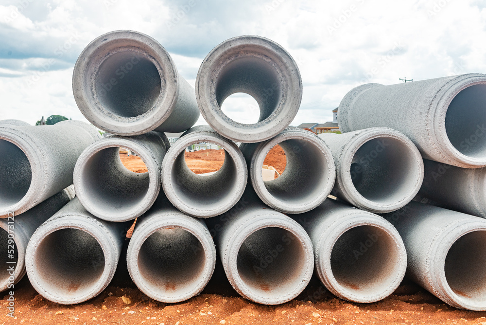 new concrete pipes stacked on a construction site. Preparation for the manufacture of the sewer system. new concrete pipes stacked on a construction site. Preparation for the manufacture of the sewer system.