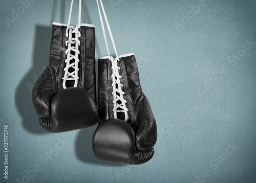 Classic boxing gloves on desk background. © BillionPhotos.com