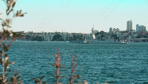 Tugboats assist an Australian Navy ship in the harbour.