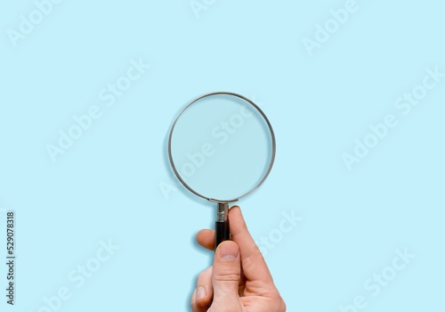 Male hand holds a magnifier focusing. To focus on the current situation, positive thinking mindset concept.