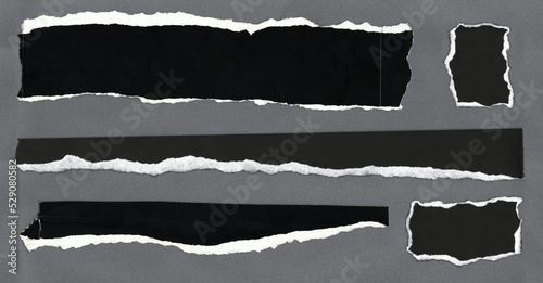 torn torn black cardboard paper pieces on gray background photo