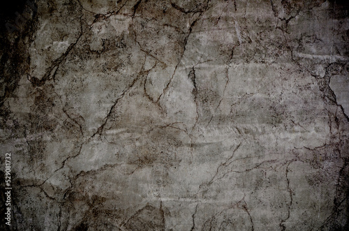 Scary horror grunge background. Cracked rock surface texture in the dark.