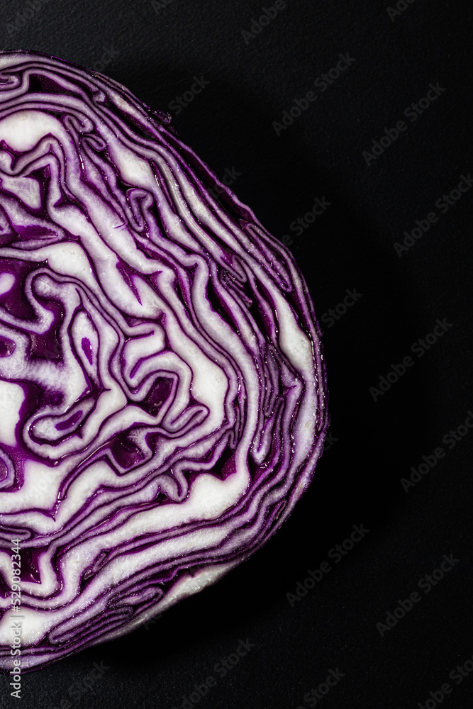 Obraz premium Purple cabbage cut ob a black board