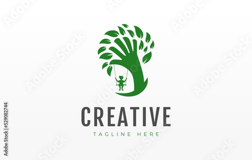 Daycare Children Wood Logo Design Template. Kids play the swing under the tree.