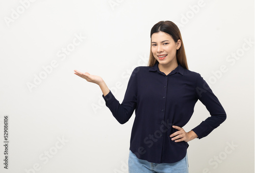 Young beautiful woman open hands palm up holding something. Happy cheerful female on isolated white background. Pointing to blank space for advertise text.