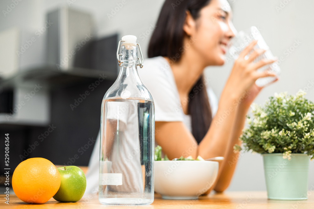 Young female drinking water in glass for refreshing for diet and wellness on table. Beautiful woman happily drink fresh water before breakfast in kitchen in the morning. Healthy food concept. Young female drinking water in glass for refreshing for diet and wellness on table. Beautiful woman happily drink fresh water before breakfast in kitchen in the morning. Healthy food concept.