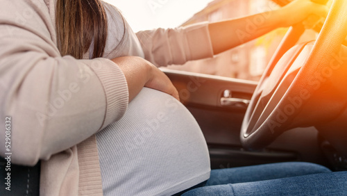 Pregnancy woman driving car. Young smiling pregnant woman driving car. Safety pregnancy young mother drive concept. © Maksym
