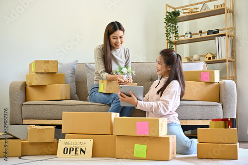 Asian female small e-commerce business owners working together in living room. © bongkarn