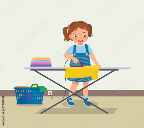 cute little girl ironing clothes doing daily chores housework activity 