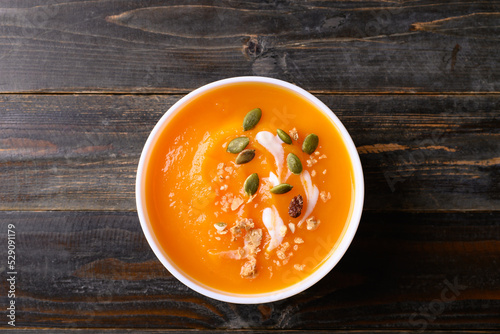 Butternut squash pumpkin soup in bowl on wooden background, Homemade food in autumn season