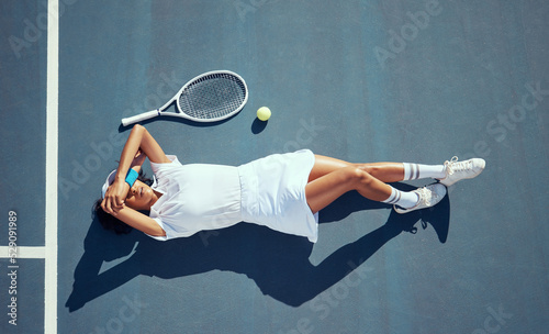 Fototapeta Naklejka Na Ścianę i Meble -  Woman tennis athlete tired and exhausted after training, exercise or practice for a game. Female professional loss of energy after a hard workout during a sports match on a court with ball and racket