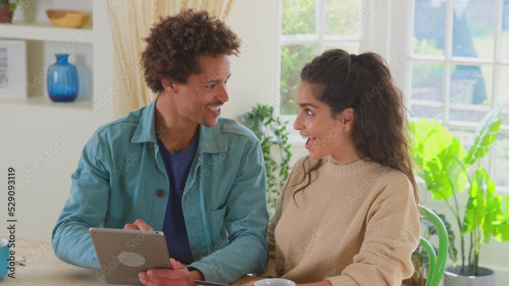 Couple with credit card at home using digital tablet to review finances for starting business - shot in slow motion Couple with credit card at home using digital tablet to review finances for starting business - shot in slow motion