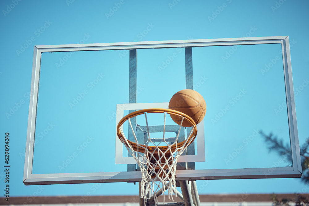 Basketball court, sport and hoop or ring net against a blue sky outside. Exercise, competitive and fun hobby for athletes with a ball on the basket for a goal with copy space or mock up outdoors Basketball court, sport and hoop or ring net against a blue sky outside. Exercise, competitive and fun hobby for athletes with a ball on the basket for a goal with copy space or mock up outdoors