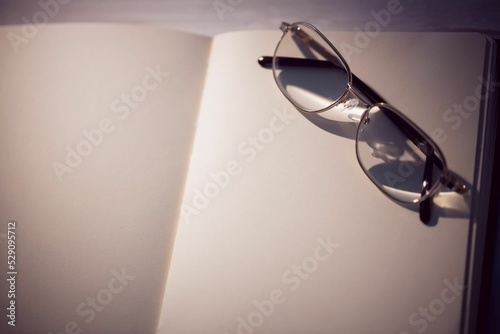Golden eyeglasses kept on blank book