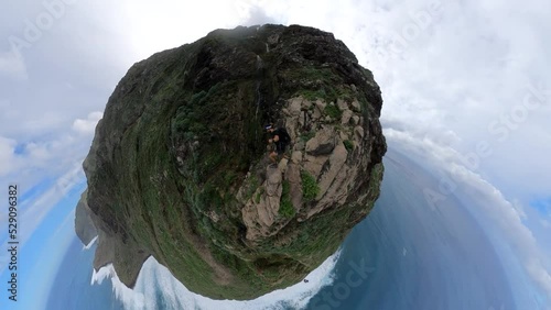 Selfie shot of a man reaching the very edge of Quebrada do Negro in Madeira. Careful steps onto the rock at the steep edge.