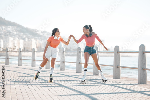 Black women, fist bump and roller skating happy friends by the sea, ocean or shore outdoors. Support, partnership and girl team collaboration or fun while traveling down promenade together. photo