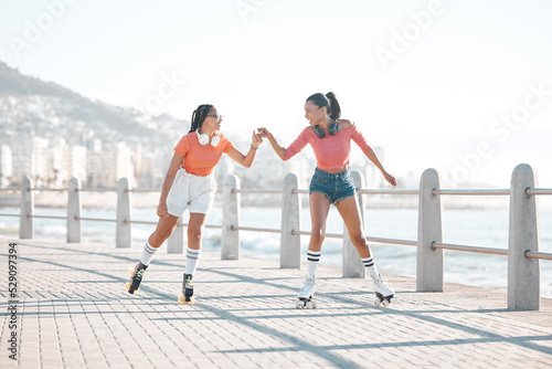 Fotografia Black women, fist bump and roller skating happy friends by the sea, ocean or shore outdoors