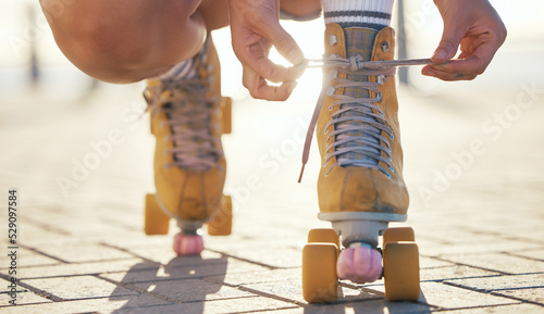 Yellow roller skates shoes of woman in summer outdoor travel, journey or fun activity for the holiday. Cool, trendy or funky gen z person prepare or tie laces on ground in quad skating with sunshine photo