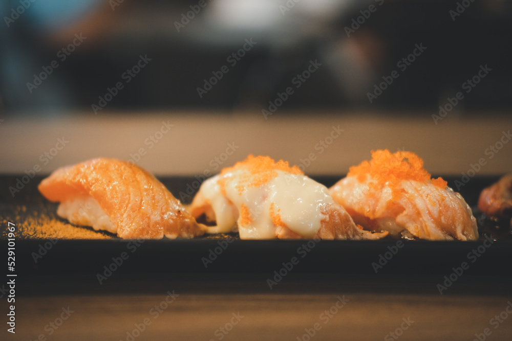 Fresh Japanese sushi salmon in Japanese restaurant. Eating Japanese food such as salmon sushi and sashimi is healthy and tasty. Salmon sushi and Japanese food concept. Fresh Japanese sushi salmon in Japanese restaurant. Eating Japanese food such as salmon sushi and sashimi is healthy and tasty. Salmon sushi and Japanese food concept.
