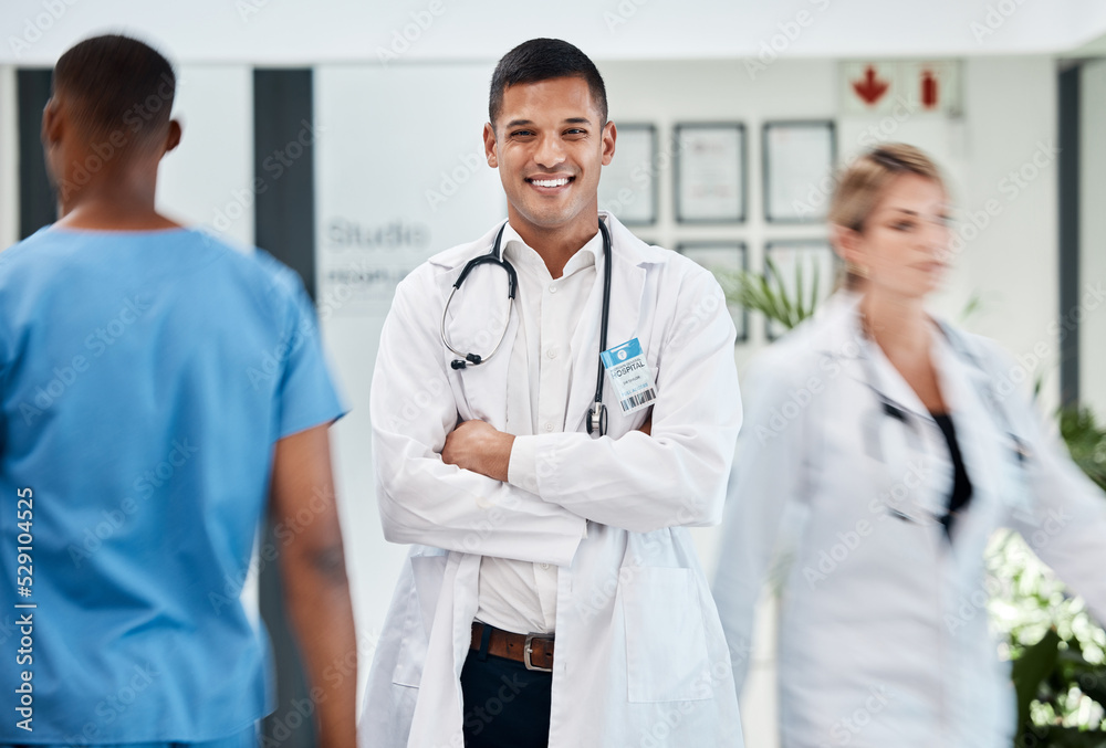 Happy, medical and doctor in hospital with smile and confident, arms crossed in busy hallway. Male, surgeon and healthcare specialist physician in hospital. Staff, clinical internship. Happy, medical and doctor in hospital with smile and confident, arms crossed in busy hallway. Male, surgeon and healthcare specialist physician in hospital. Staff, clinical internship.