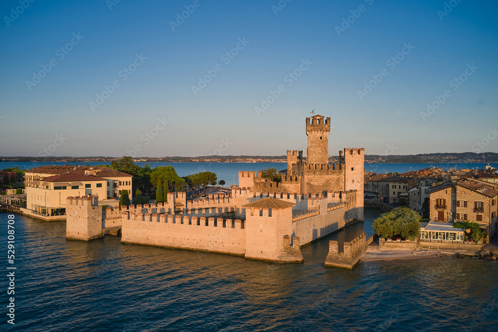 View of Scaligero Castle at sunrise. Historic part of the city of Sirmione view on Lake Garda, Italy. Historic Water Castle on Lake Garda.