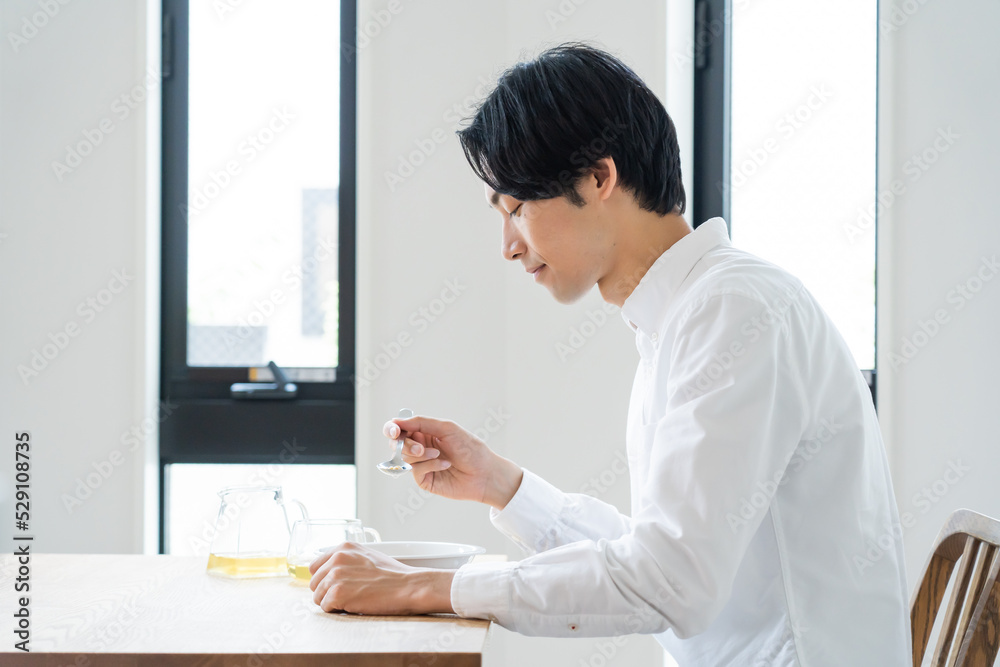 自宅でシリアルを食べる健康的な日本人男性