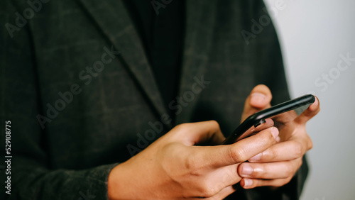 Close-up businessman holding a mobile phone, checking information and communicating.