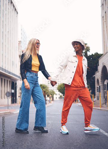 Happy interracial couple with fashion clothing in a urban city street with a smile and love. Trendy, stylish or punk man and woman walking in a town road with funky, edgy and style together photo