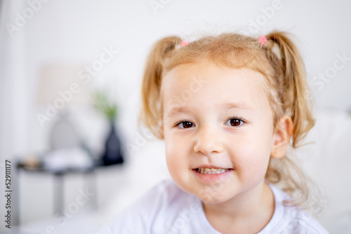 portrait of a cute little girl with white hair, the face of a smiling blonde child