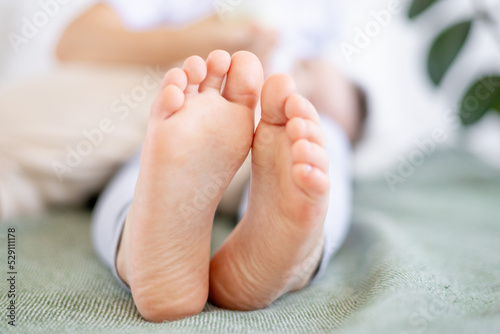 the feet of a small child on a green bed, the heels of a baby close-up © Any Grant