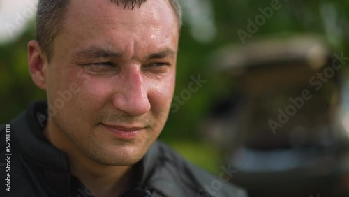 Gentleman in jacket closes eyes partly on blurred background photo