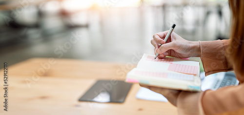 Schilderij op canvas Closeup of woman's hand writing note on schedule book, business banner background