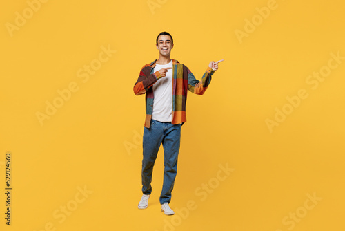 Full body young fun middle eastern man 20s wear casual shirt white t-shirt pointing indicate on workspace area copy space mock up isolated on plain yellow background studio People lifestyle concept
