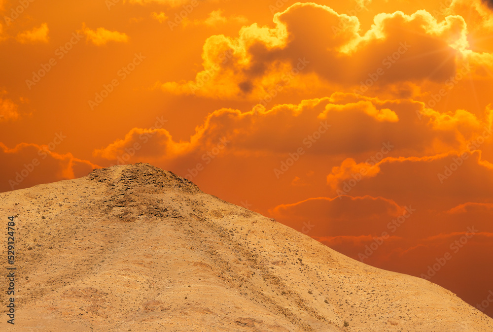Sunset in the desert and sun rays spreading over mountain Sodom
