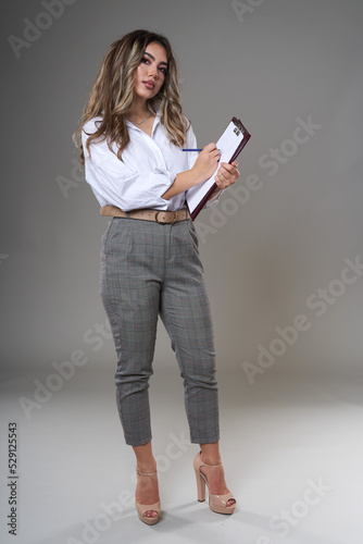 Young businesswoman with documents on gray
