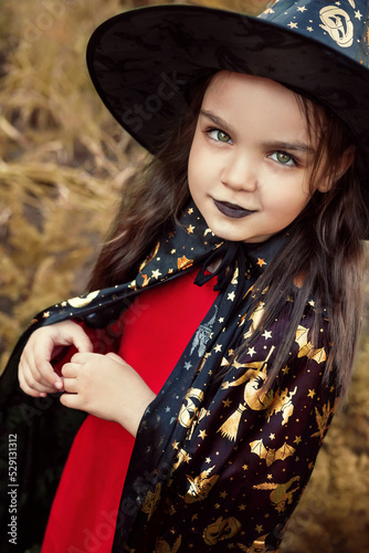 A girl with painted black lips dressed as a witch.  Halloween celebration. Portrait of a woman