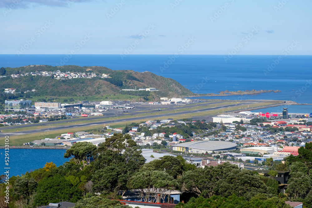 Wellington International Airport runway surrounded by water ocean and residential houses in Capital Wellington, New Zealand Aotearoa