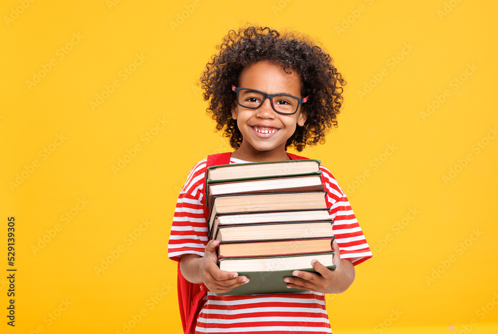 Excited ethnic schoolboy with books laughing Excited ethnic schoolboy with books laughing